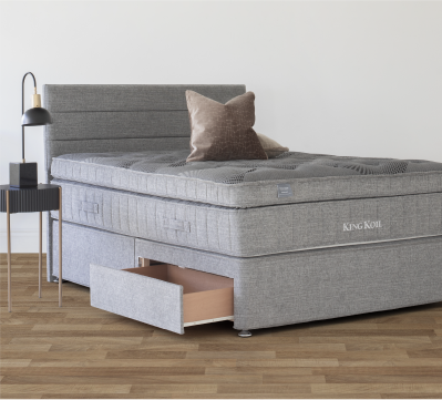 Grey mattress with a storage base drawer in a modern bedroom.