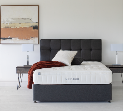 White mattress with a dark upholstered headboard in a modern bedroom.
