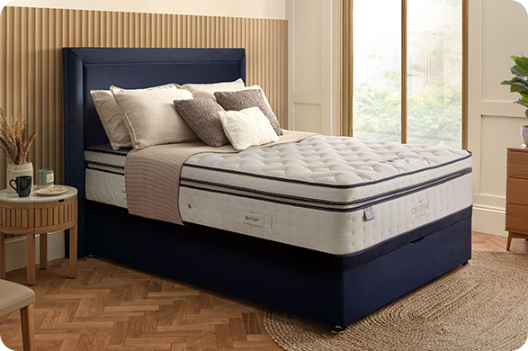 Sleep Supreme mattress on a navy fabric bed in a modern bedroom.